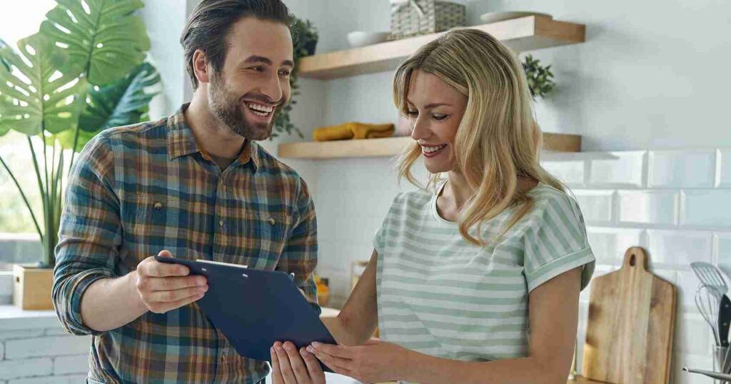 Male-plumber-and-female-customer-laughing-and-looking-at-invoice